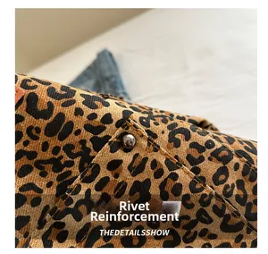 Close-up of leopard print fabric with durable rivet reinforcement on the seam detail