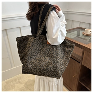 Close-up of leopard print tote bag featuring metallic rivets and canvas texture