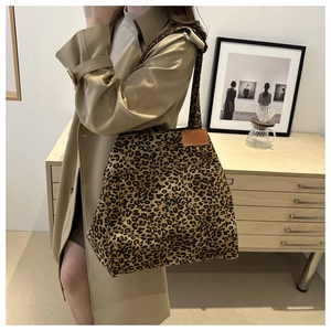 Close-up of leopard print canvas tote bag with a minimalist brown leather patch detail