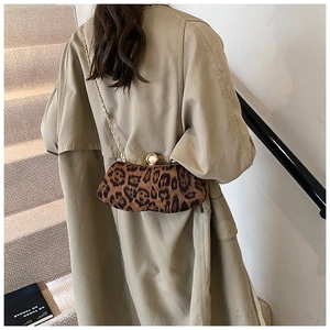 Détail d'un sac léopard avec bandoulière chaîne dorée et fermoir en perle élégant