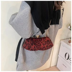 Détail d'un sac léopard rouge avec fermoir perle géante et bandoulière dorée