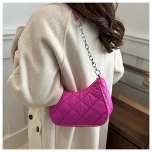 Detail of rose red quilted half-moon bag on beige coat with chain strap and stitching