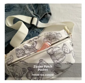 Detailansicht der seitlichen Reißverschlusstasche an einer weißen Segeltuch-Brusttasche