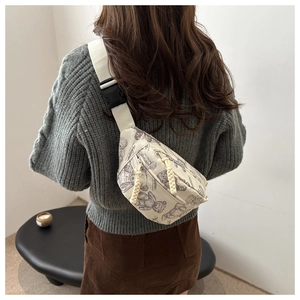 Detail der cremefarbenen Umhängetasche mit Teddybär-Print und verstellbarem Gurt am Model