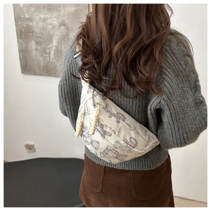 Detail der trendigen cremeweißen Gürteltasche mit Bärenprint und Web-Reißverschluss
