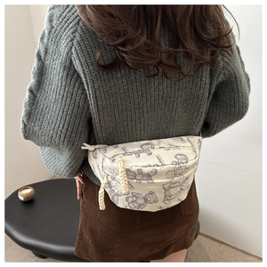 Nahaufnahme der cremefarbenen Brusttasche mit Vintage Bär-Druck und Seil-Reißverschluss