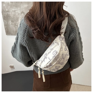 Detailansicht der weißen Brusttasche mit Teddybär-Print und Kordel-Reißverschluss