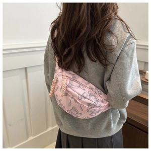 Detail der rosa Umhängetasche mit Bärenprints, getragen über einem grauen Hoodie