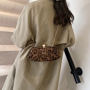 Sac bandoulière léopard en fausse fourrure avec fermoir perle et chaîne dorée porté par mannequin