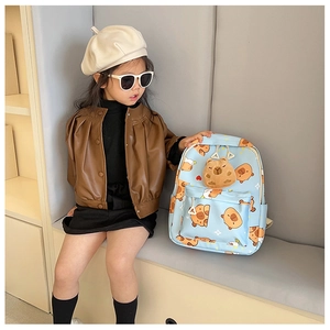 Detailaufnahme des hellblauen Kinderrucksacks mit Capybara-Print und Plüsch-Anhänger