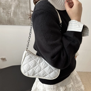 Chic white quilted crossbody bag with silver chain strap shown on model's shoulder