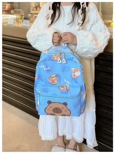 Sky blue kids backpack featuring cute cartoon capybara print in a cozy bakery setting