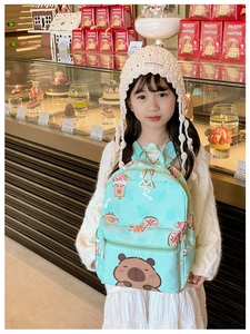 Girl wearing mint green Capybara backpack in a cozy bakery shop setting with soft lighting