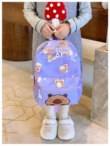 Detail of purple children backpack with cute cartoon capybara prints and zipper pocket