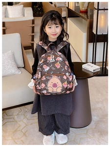 Detail view of brown Capybara cartoon backpack showing front zipper pocket and canvas texture