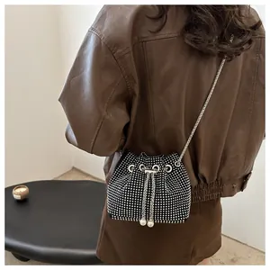 Détail du sac seau en strass avec perles de serrage et bandoulière chaîne argent