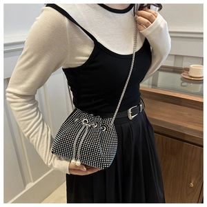 Détail d'un sac seau noir en strass avec de grandes perles et une bandoulière chaîne argent