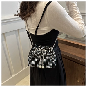 Détail du sac seau en strass avec fermeture par cordon et bandoulière en chaîne