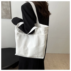 Spacious white canvas tote bag shown from a side-rear angle with strong load-bearing detail