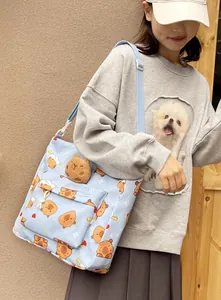 Detail of light blue crossbody bag with bear print and cute plush bear charm