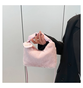 Detailed close-up of pink faux fur plush handbag with ruffled leather top handle