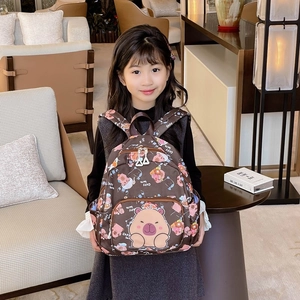 Cute dark brown capybara cartoon backpack for children shown on a young model in a home setting