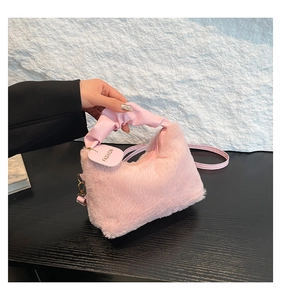 Detailed close-up of pink faux fur texture and leather handle with gold zipper hardware