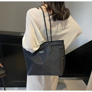 Detail of the high-quality nylon tote bag with leather straps and a fashion label