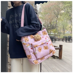 Pink canvas tote bag featuring cute cartoon capybara print and plush pendant on strap