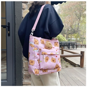 Pink capybara print shoulder bag featuring a cute 3D plush charm on outdoor terrace