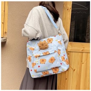 Detail of light blue Capybara canvas tote bag with 3D plush doll and adjustable strap