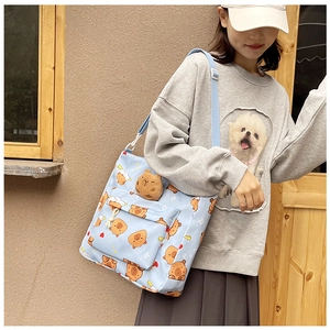 Detail of light blue capybara canvas bag with matching plush pendant and shoulder strap