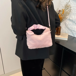 Pink faux fur handbag with soft plush texture and adjustable shoulder strap for women