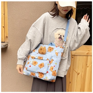 Detailed view of light blue Capybara print tote bag with a matching plush charm