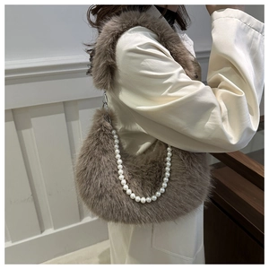 Détail du sac en fausse fourrure marron avec une élégante anse en grosses perles blanches