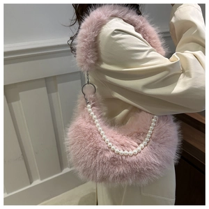 Détail du sac en fausse fourrure rose avec perles décoratives et boucle métallique