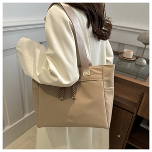 Détail d'un sac cabas en toile beige avec cordon de serrage et large bandoulière
