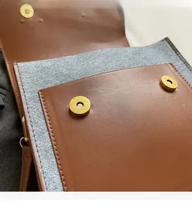 Detail view of strong dual magnetic gold buckles on a brown leather backpack interior