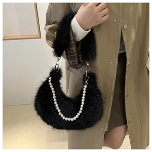 Détail du sac demi-lune en fausse fourrure noire avec chaîne perle et manteau