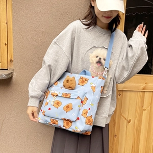 Light blue canvas shoulder bag featuring cute Capybara prints and a plush doll decoration