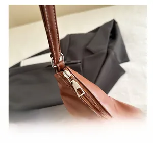 Detailed close-up of premium brown leather bag showing metal zipper and contrast stitching