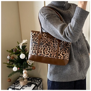 Detailed side view of leopard print tote bag with brown leather accents and logo patch