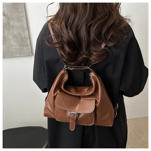 Vue arrière d'un sac à dos vintage en cuir marron avec poignée et poches à boucles