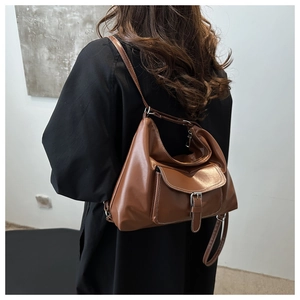 Détail d'un sac à bandoulière marron vintage en simili cuir avec boucle argentée et poche à rabat