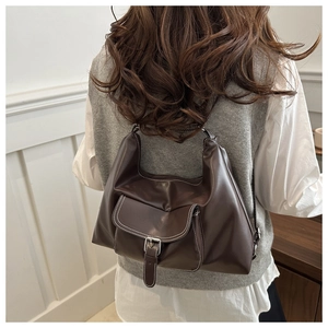 Detail showing contrast stitching and silver buckle on dark brown hobo tote bag