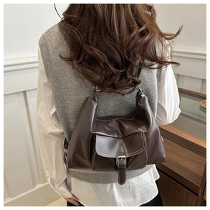 Détail du sac bandoulière marron foncé en similicuir avec surpiqûres blanches et boucle