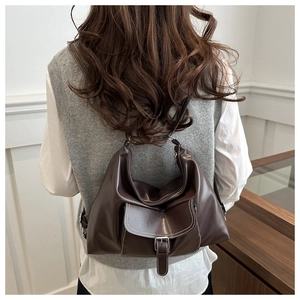 Détail du sac bandoulière en cuir marron avec boucle argentée et coutures contrastées