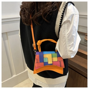 Détail du sac à main en patchwork multicolore avec poignée orange et base incurvée