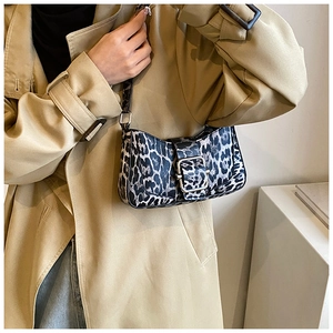 Vue détaillée du sac croissant imprimé léopard sur un trench-coat pour un look élégant