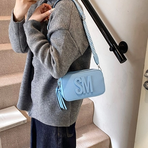 Light blue faux leather crossbody bag with SM embossed logo and woven wide strap